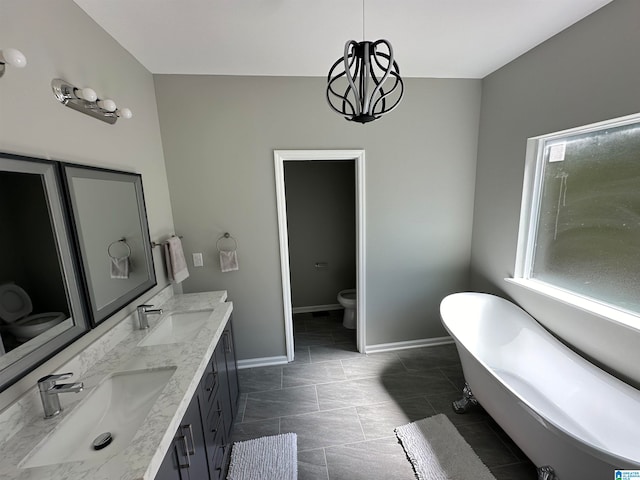 bathroom with tile patterned floors, toilet, vanity, and a bathing tub