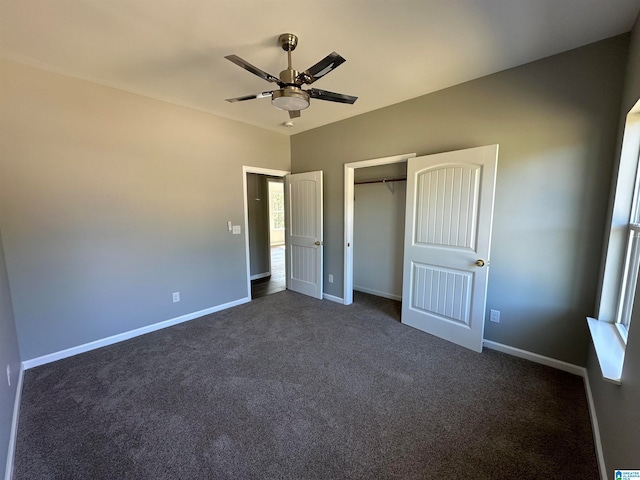 unfurnished bedroom with a closet, dark colored carpet, and ceiling fan