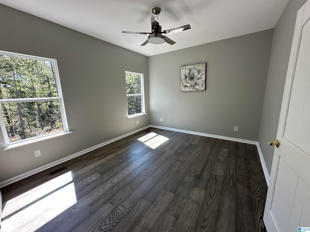 spare room featuring ceiling fan, dark hardwood / wood-style flooring, and a wealth of natural light