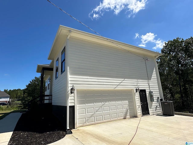 view of side of property featuring central air condition unit and a garage