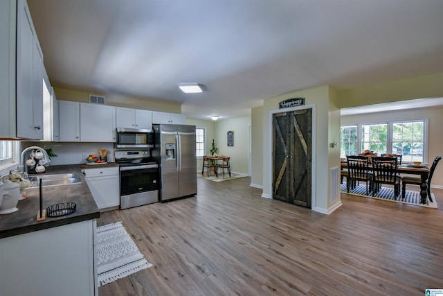 kitchen featuring light hardwood / wood-style flooring, stainless steel appliances, sink, and white cabinetry