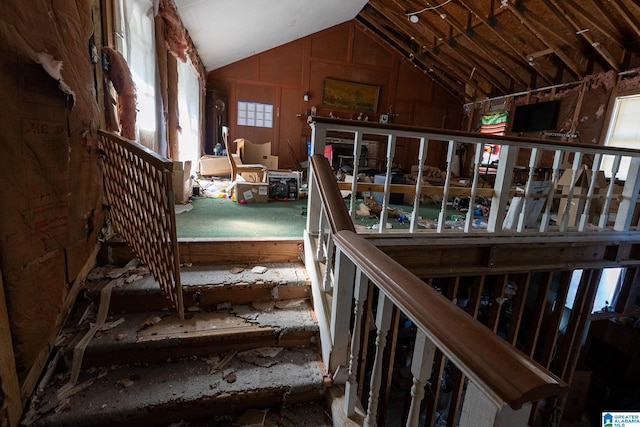 staircase featuring a healthy amount of sunlight and lofted ceiling