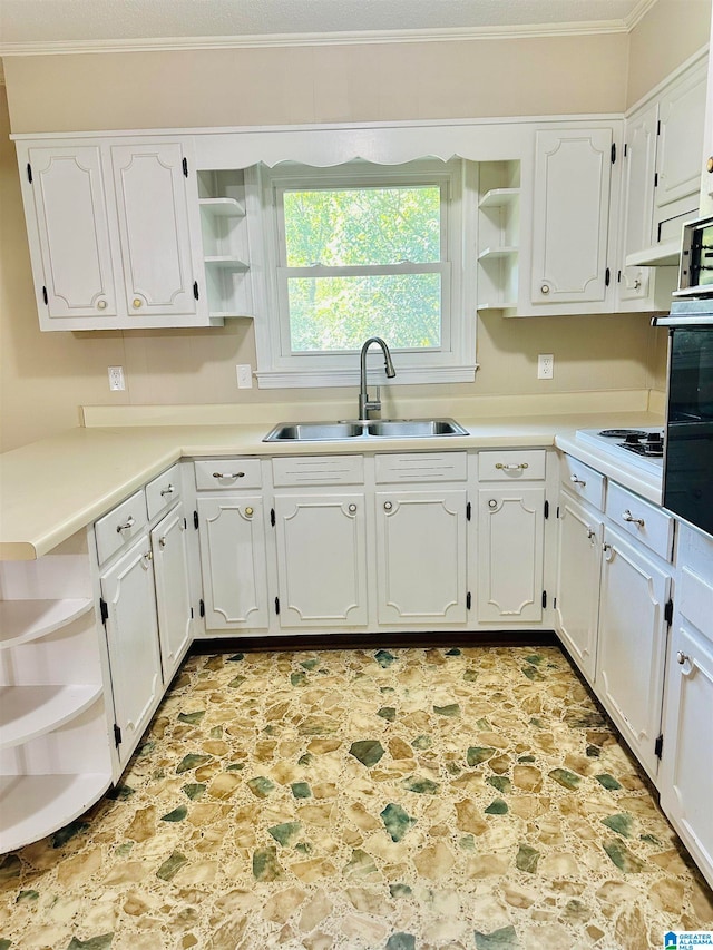 kitchen featuring ornamental molding, white cabinetry, black oven, and sink