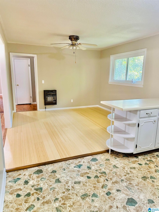 interior space featuring light hardwood / wood-style floors, a fireplace, ceiling fan, and heating unit