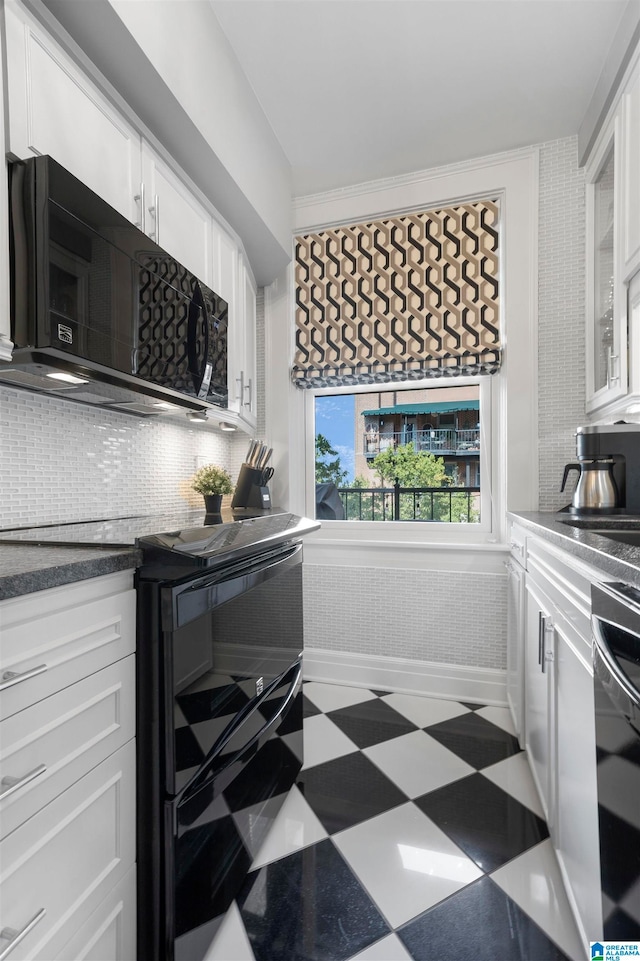 kitchen featuring black appliances, tasteful backsplash, and white cabinetry