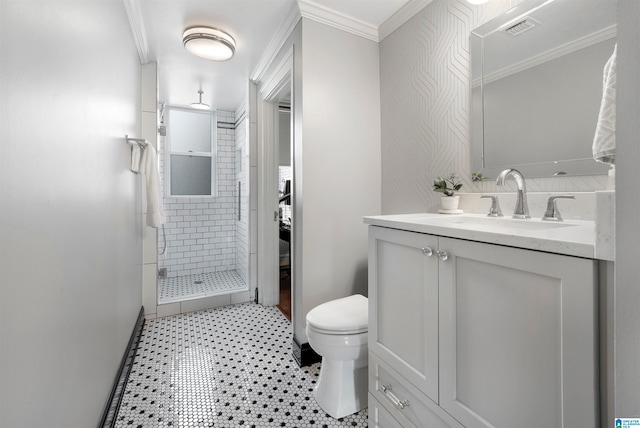 bathroom with a tile shower, tile patterned floors, ornamental molding, vanity, and toilet