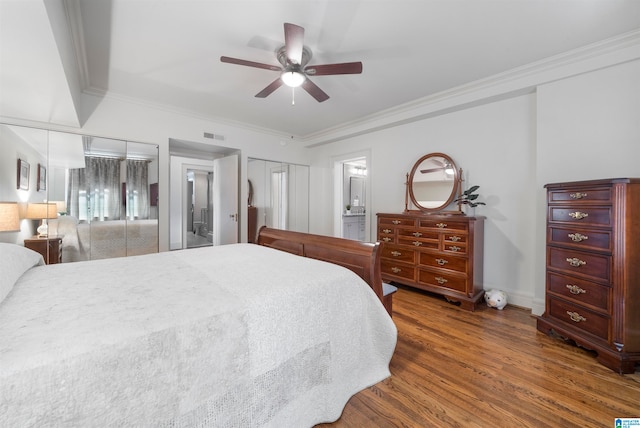 bedroom featuring ornamental molding, ensuite bath, ceiling fan, and dark wood-type flooring