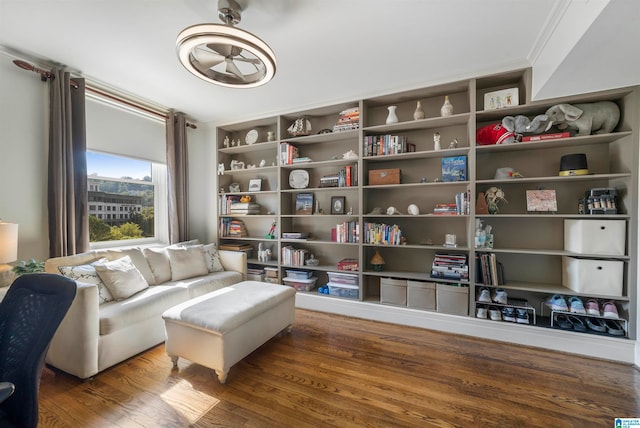 living area with ornamental molding, hardwood / wood-style floors, and ceiling fan