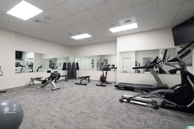 workout area featuring carpet floors and a paneled ceiling