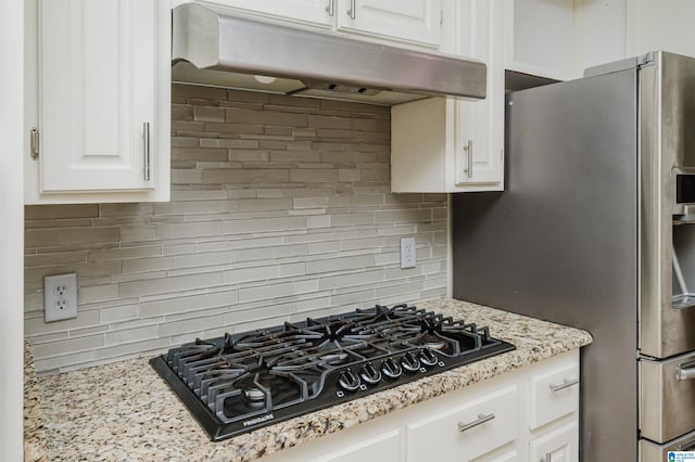 kitchen featuring light stone counters, black gas cooktop, tasteful backsplash, and white cabinetry