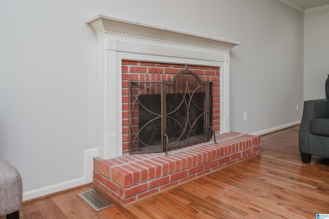 room details with a fireplace, ornamental molding, and hardwood / wood-style flooring