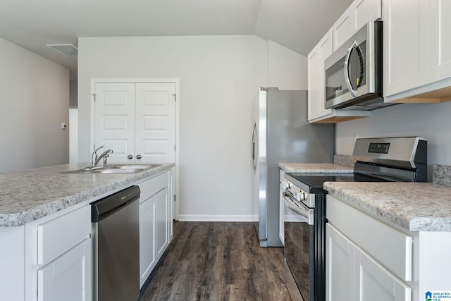 kitchen featuring visible vents, stainless steel appliances, dark wood-type flooring, white cabinetry, and a sink