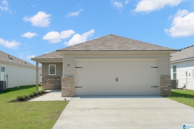 view of front facade with concrete driveway, brick siding, a front lawn, a shingled roof, and central AC