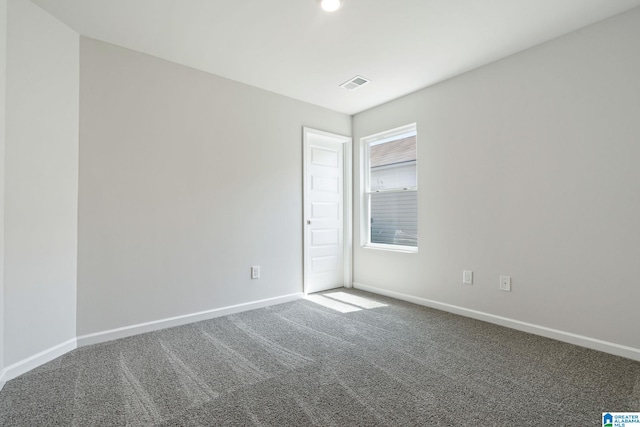 spare room featuring baseboards, visible vents, and carpet flooring