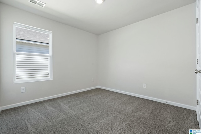 empty room featuring carpet, baseboards, and visible vents