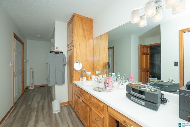 bathroom with wood-type flooring, vanity, and a textured ceiling