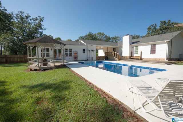 view of swimming pool featuring a deck, a yard, and a patio area