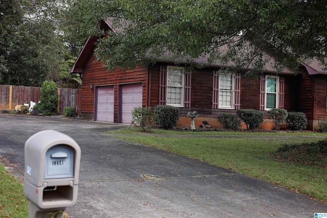 view of side of home featuring a lawn and a garage