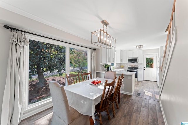 dining space featuring an inviting chandelier, dark hardwood / wood-style floors, ornamental molding, and sink