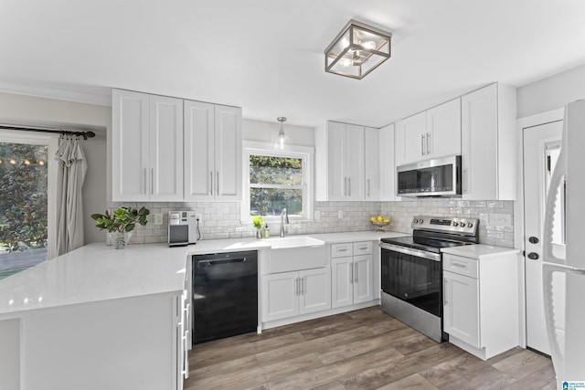 2825 Cahawba Trl, Birmingham, AL 35243 - kitchen featuring a peninsula, light wood-style flooring, white cabinets, appliances with stainless steel finishes, and a sink