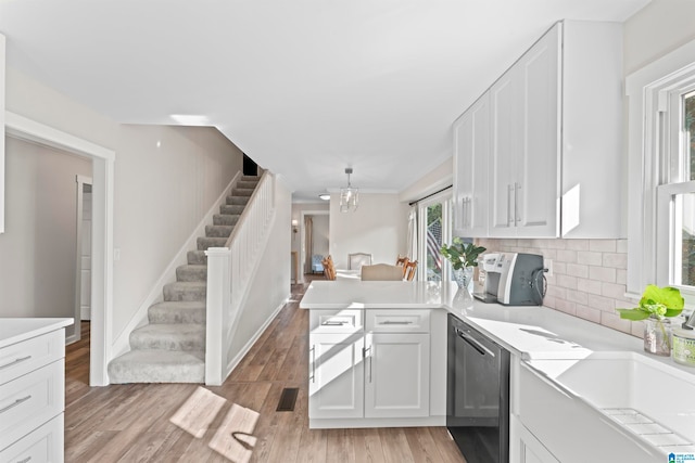 kitchen featuring light wood-type flooring, plenty of natural light, kitchen peninsula, and white cabinetry