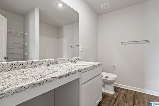 bathroom featuring vanity, hardwood / wood-style floors, and toilet