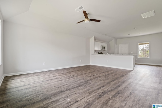 unfurnished living room with lofted ceiling, dark hardwood / wood-style floors, ceiling fan, and sink