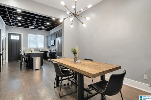 dining space with an inviting chandelier, sink, and dark hardwood / wood-style flooring