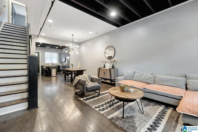 living room featuring beamed ceiling, a notable chandelier, and dark hardwood / wood-style floors