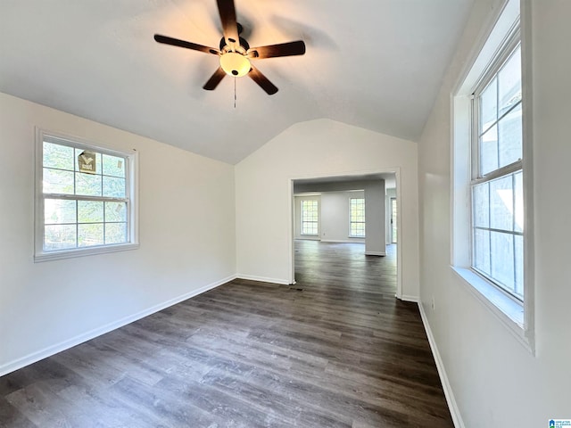 unfurnished room featuring lofted ceiling, dark wood-type flooring, ceiling fan, and plenty of natural light