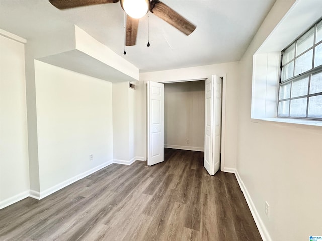 unfurnished bedroom with dark wood-type flooring, ceiling fan, and a closet