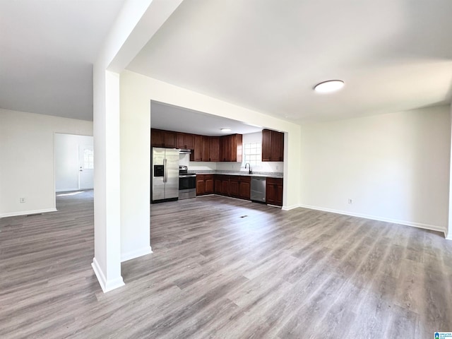 unfurnished living room with light wood-type flooring and sink