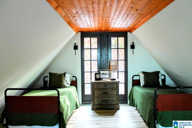 bedroom with light hardwood / wood-style flooring, vaulted ceiling, and wood ceiling