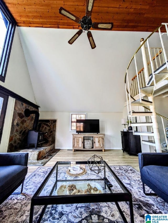 living room featuring ceiling fan, a wood stove, high vaulted ceiling, and wooden ceiling