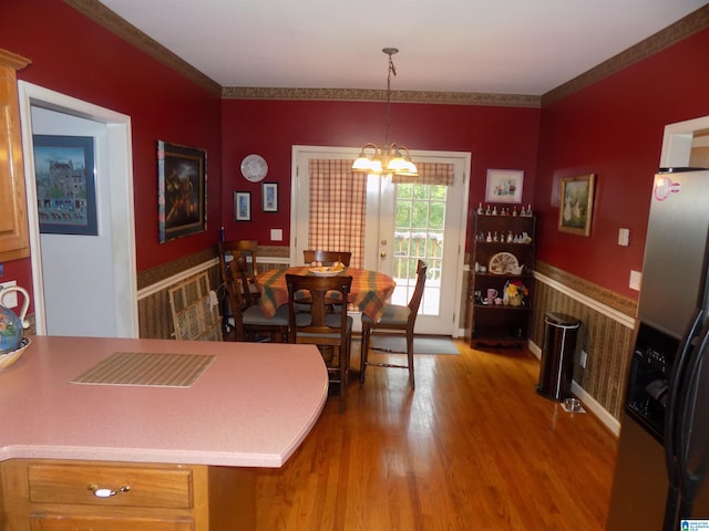 dining room featuring a notable chandelier, crown molding, french doors, and hardwood / wood-style flooring