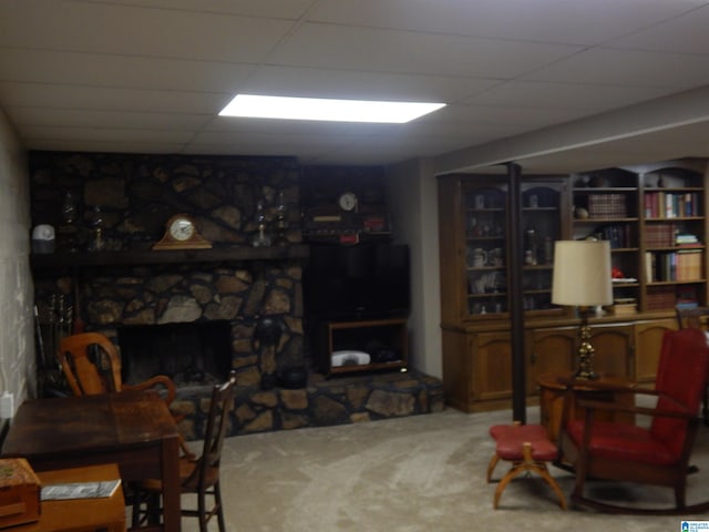 living room with a fireplace, carpet flooring, and a drop ceiling