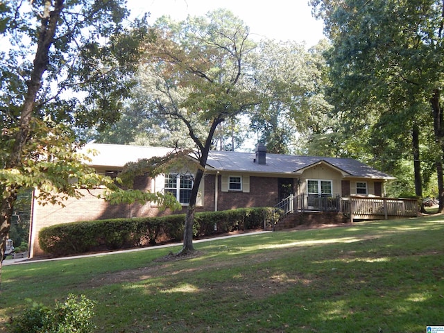 single story home with a wooden deck and a front yard