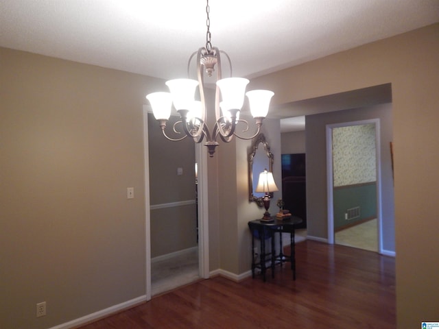 dining space with an inviting chandelier and dark hardwood / wood-style flooring