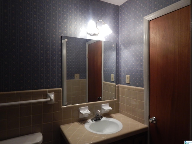 bathroom with vanity, tile walls, and toilet