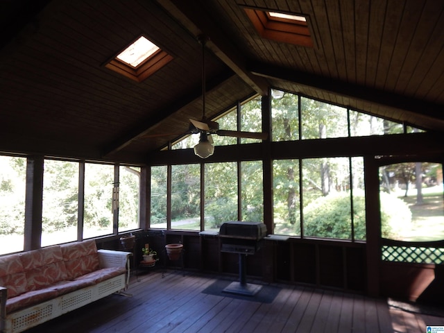 sunroom featuring ceiling fan, vaulted ceiling with skylight, and a wealth of natural light