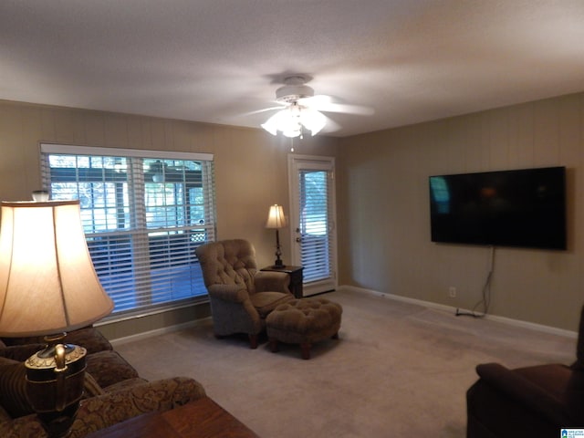 carpeted living room featuring a textured ceiling and ceiling fan