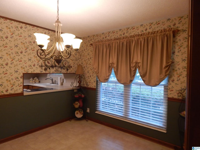 unfurnished dining area featuring sink, a chandelier, and a wealth of natural light