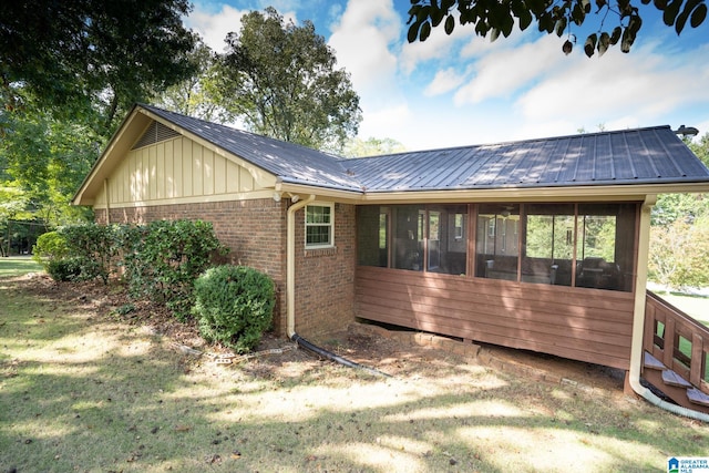 back of house with a sunroom and a yard