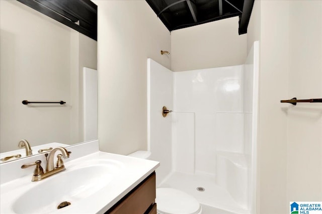 bathroom featuring walk in shower, vanity, and toilet