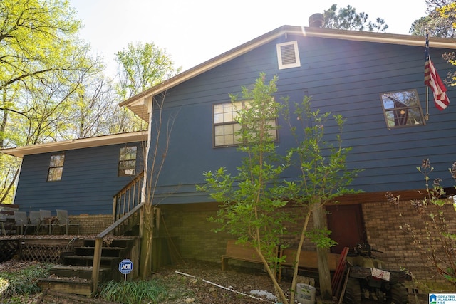 view of home's exterior with brick siding and stairway