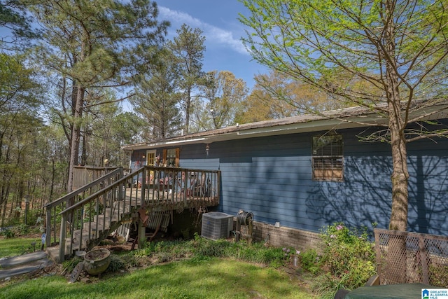 rear view of house with metal roof, cooling unit, a deck, and stairway