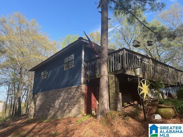 view of home's exterior featuring a wooden deck and brick siding