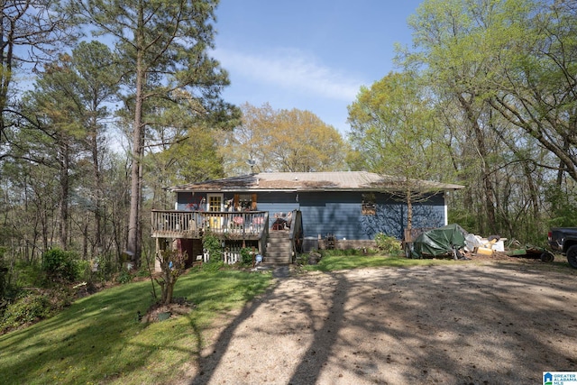 back of house with a deck and a yard