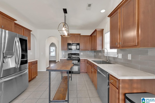 kitchen featuring light tile patterned floors, black appliances, sink, and pendant lighting