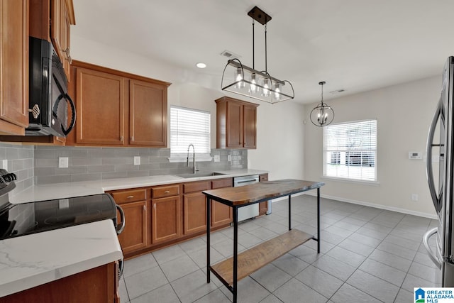 kitchen featuring appliances with stainless steel finishes, sink, plenty of natural light, and decorative light fixtures